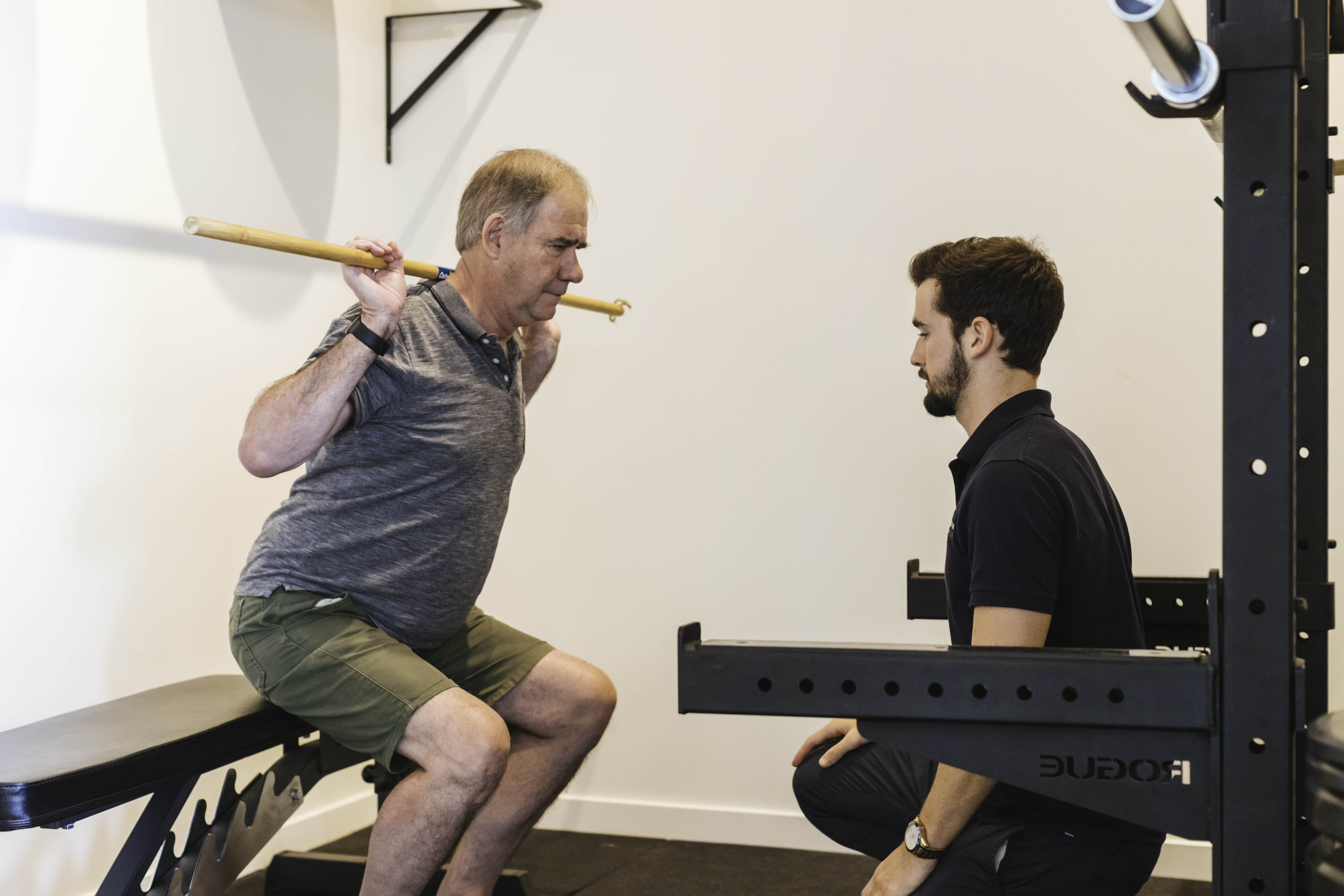 Man doing squats with a physio